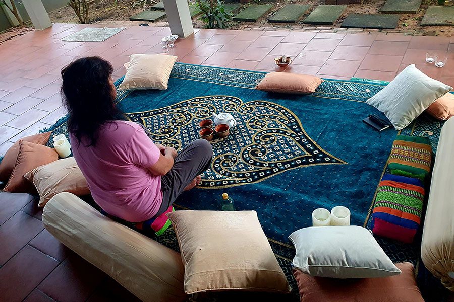 A woman meditates on a carpet at Awata, located just outside Mumbai. 